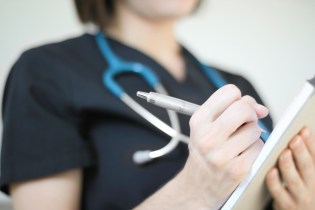 Nurse writing medication out for a patient.