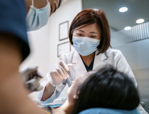 Dentist working on a patient in dental chair | Best states to practice dentistry