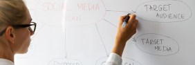 social media marketing woman drawing bubbles on a whiteboard of various marketing terms