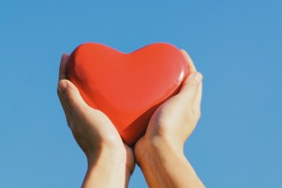 Hand holding a red wooden heart