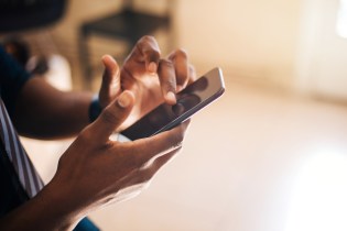 African American man scrolling through page on smartphone