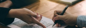 man signing real estate contract with a pen