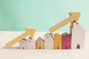 Row of wooden houses arranged from shortest to tallest with yellow arrows resting on top of them highlighting the progression of height.