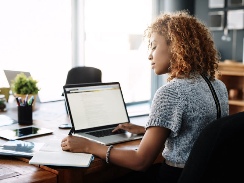 woman at laptop writing physical therapy cover letter