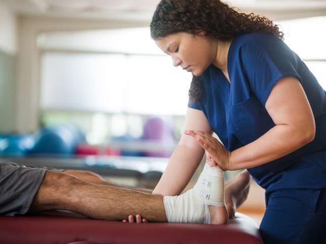 physical therapist working on patient's foot
