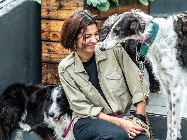 Woman walking dogs as her small business | Small business general liability insurance cost