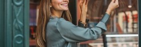 Woman hanging up an open sign outside her business while she thinks about BOP vs GL