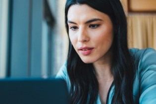 Woman searching on her laptop for Berxi insurance reviews