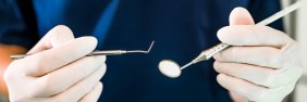 Male dentist readying tools for a patient | comparing dental malpractice insurance providers