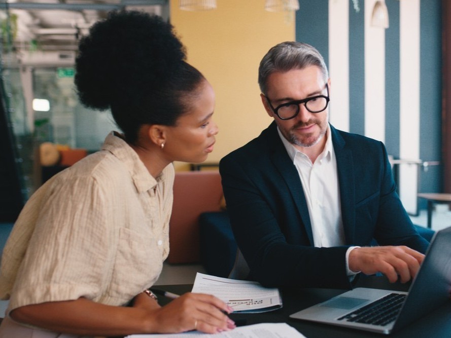Man and woman at table discussing professional liability insurance 