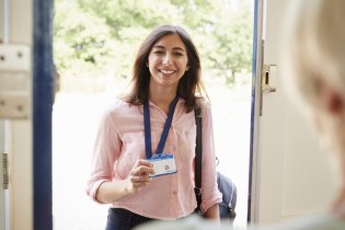 Smiling woman showing her social worker name badge | Social worker malpractice insurance coverage requirements