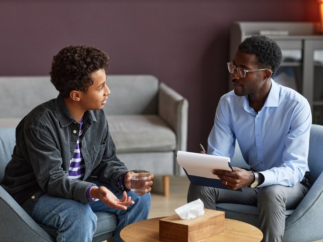 Two men sitting, having a conversation about why social worker malpractice insurance is important 