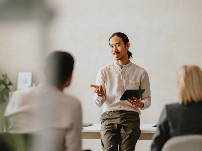 Man explaining berxi insurance to a group of seated individuals 