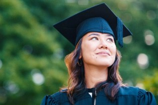 graduating female dentist in cap and gown | new dentist malpractice insurance costs