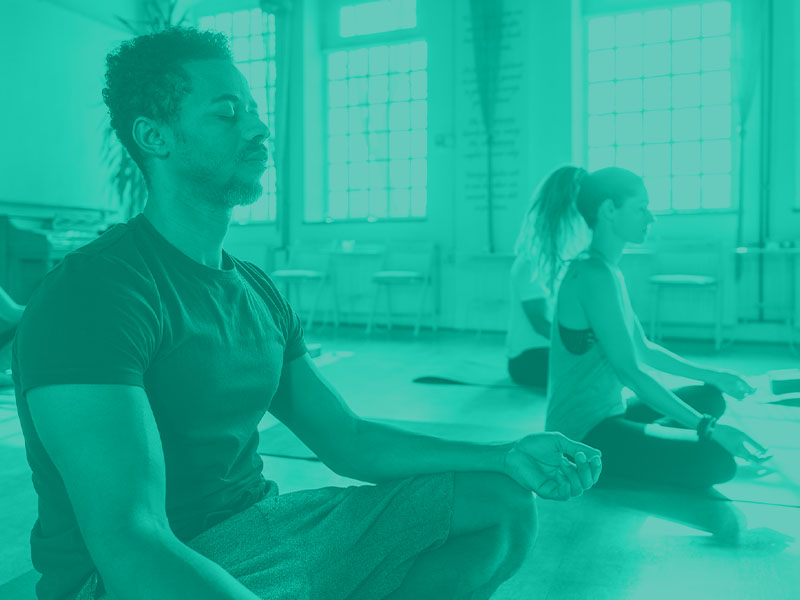 male yoga instructor leading a yoga class 