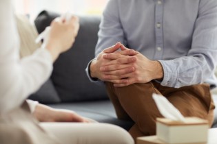 Man sitting with counselor | Counselor malpractice insurance cost
