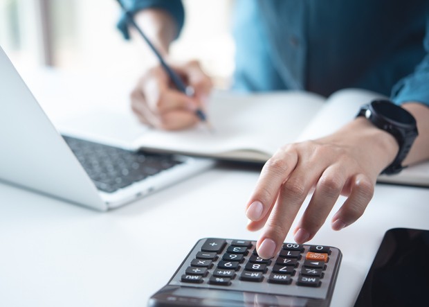 Man calculating professional liability insurance cost on his calculator