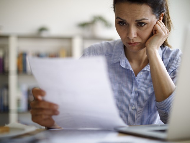 Stressed female nurse reviewing a board complaint from the nurse licensing board 