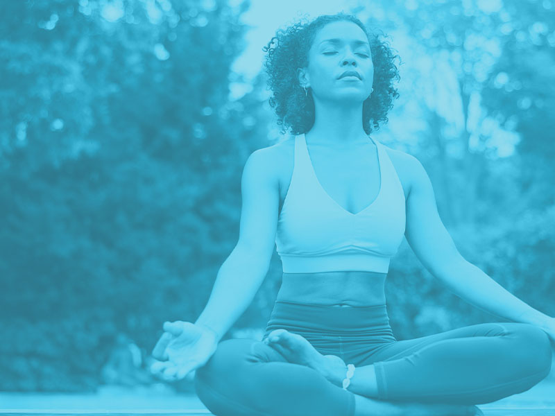 Woman with legs crossed meditating | liability insurance for yoga instructors