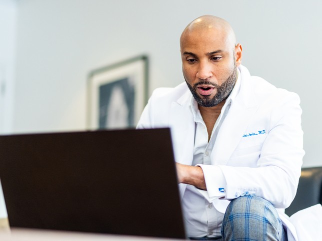 Male dentist looking for other types of insurance for dentists on his computer 