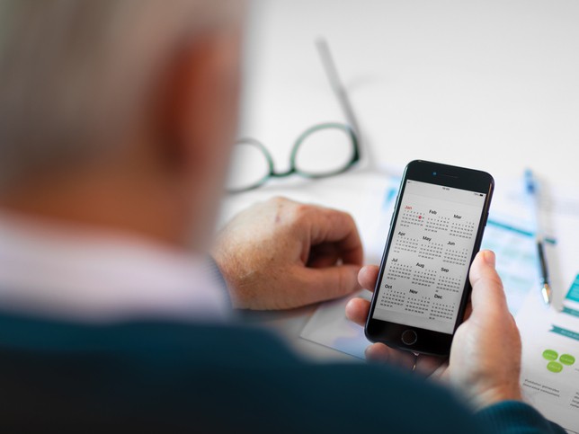 man looking a his phone calendar 