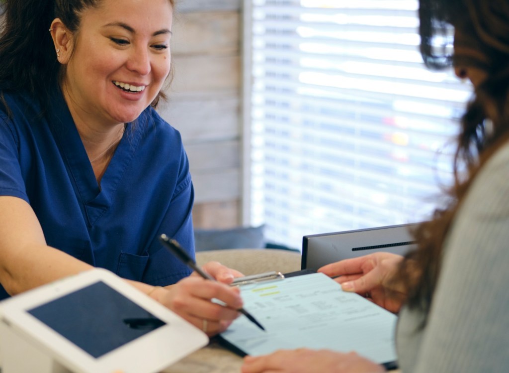 medical professional reviewing papers with patient in a medical office 