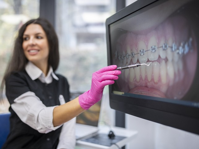 orthodontist showing teeth on a screen to a patient