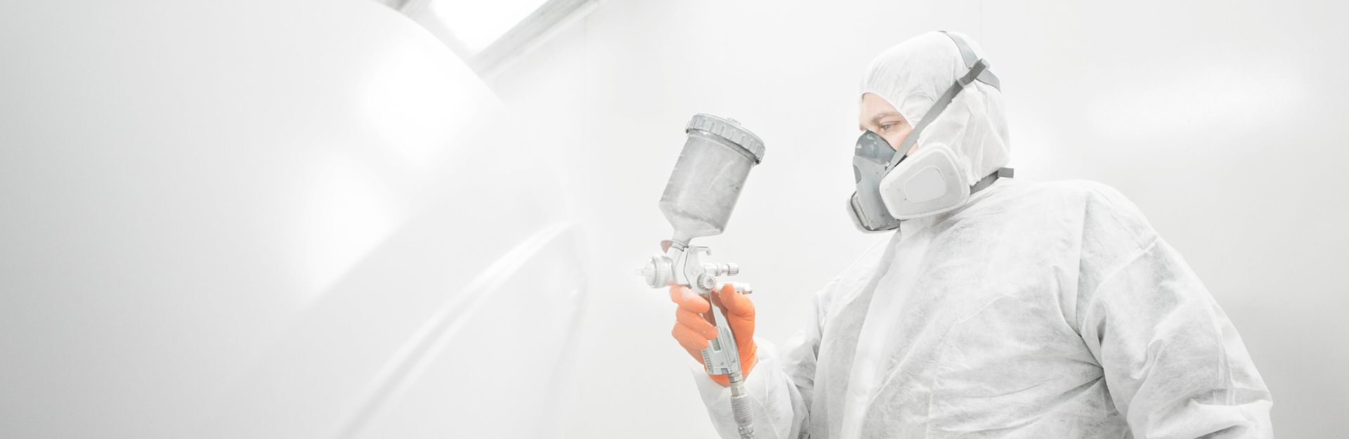 Painter spraying a room with white paint | painting professional insurance