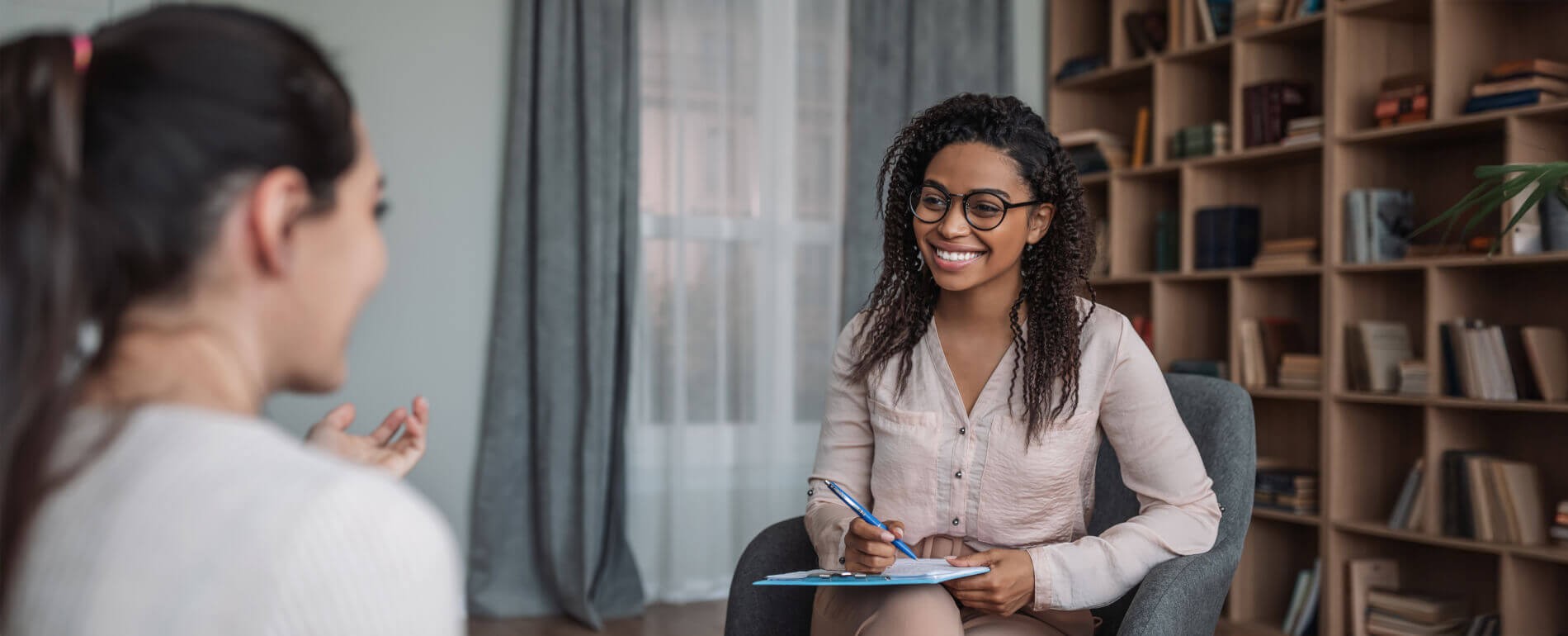 Counselor talking with woman in her office | liability insurance counselors