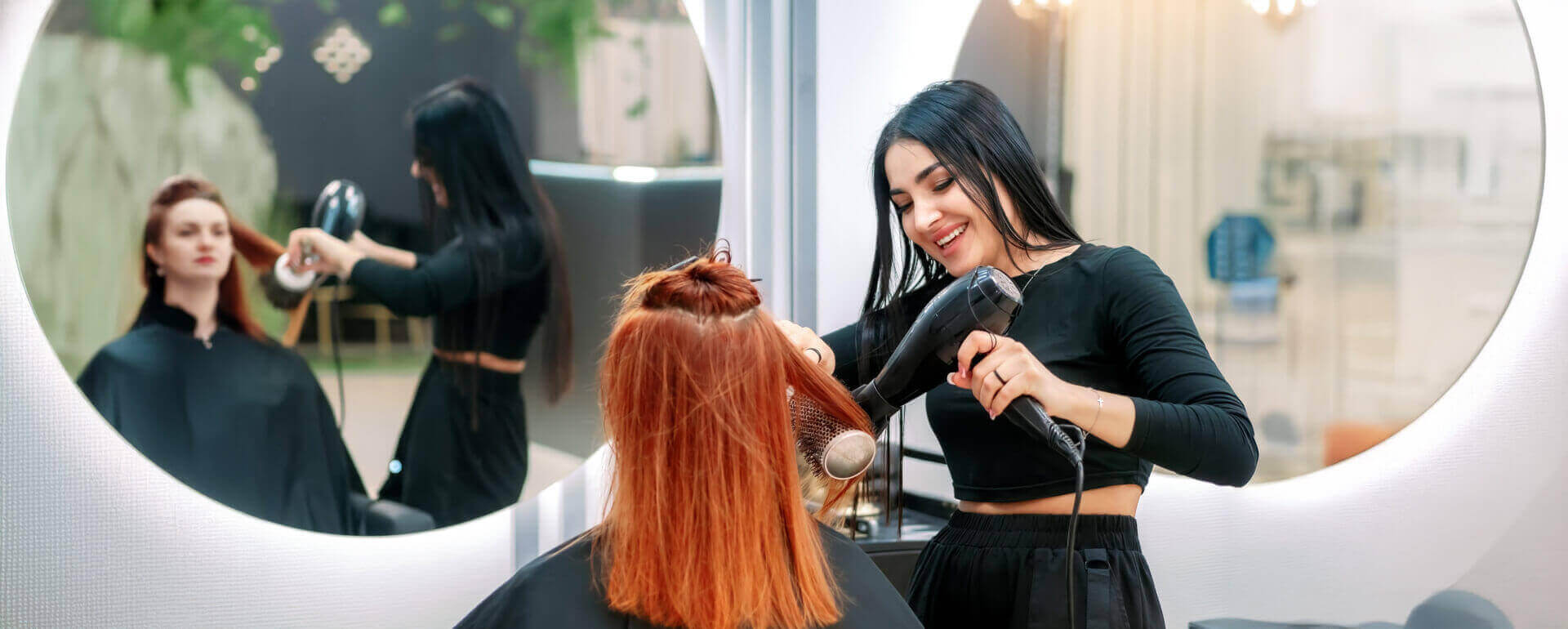 Hair dresser blow drying a woman's hair | general liability insurance for beauty salons
