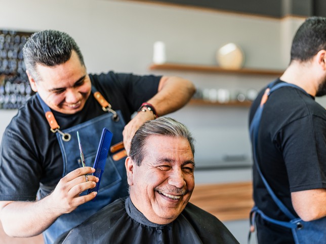 Barber cutting a client's hair in a barber chair