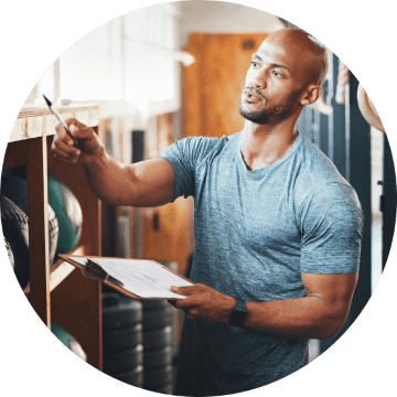 Gym owner with clipboard working in fitness facility