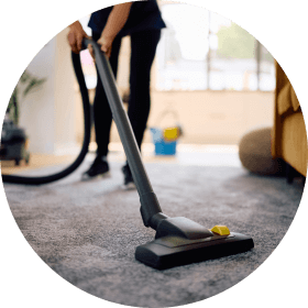 Professional house cleaner vacuuming carpet