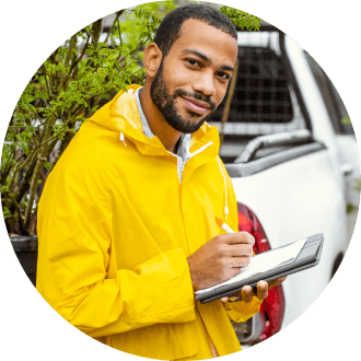 Landscaper with clipboard working near truck 