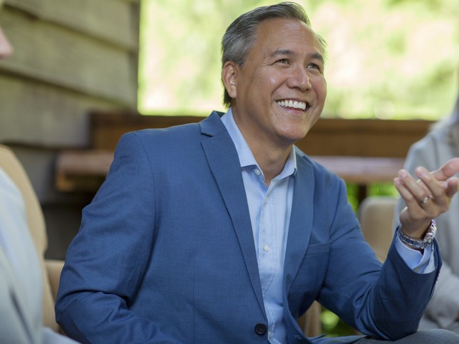 Smiling man in suit smiling while asking, "Who needs errors and omissions liability insurance?"
