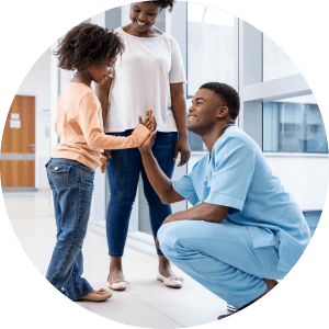 Nurse high fiving a child in a medical facility 