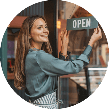 Women hanging an open sign on the front door of her business