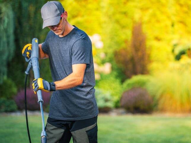 Landscaper using weedwhacker on the job 