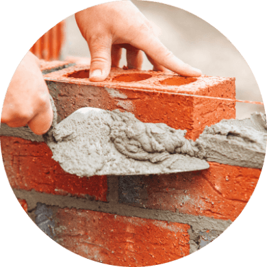 mason with trowel and cement building brick wall