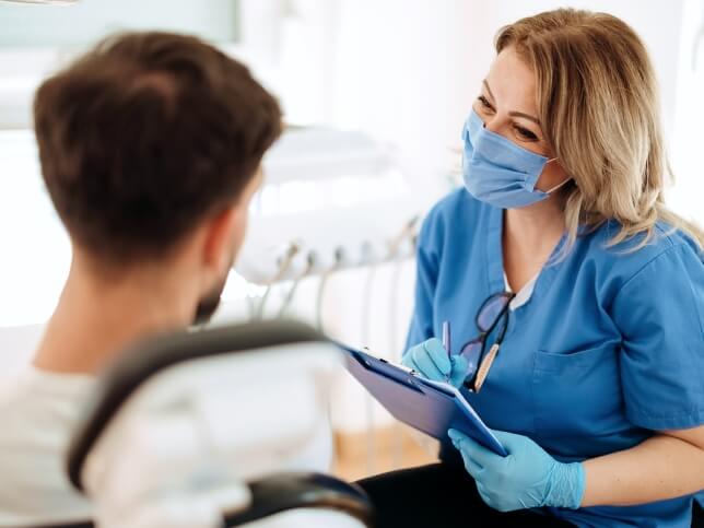 Dental professional talking with patient in a dentist office 