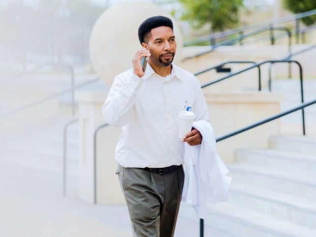 dentist holding coat on phone with insurance provider