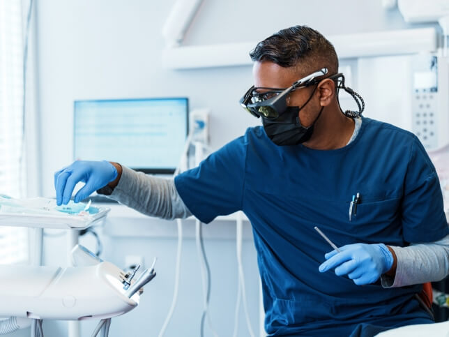 Dentist wearing mask working with tools in dental office | dental malpractice insurance tail coverage