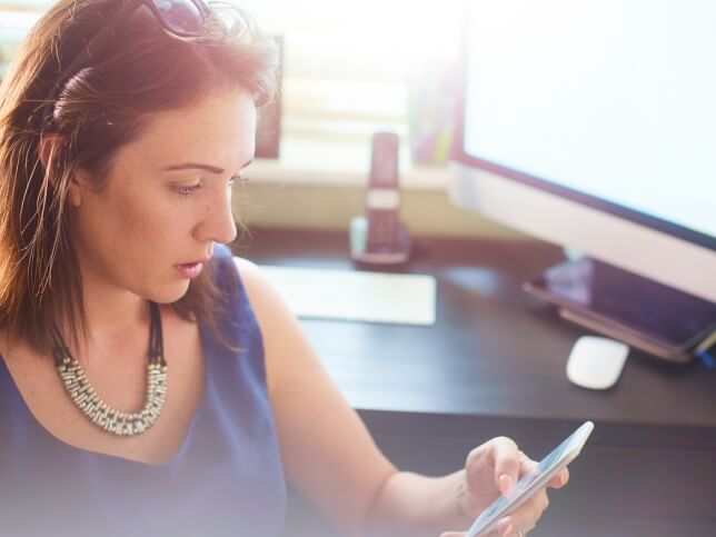 insurance agent staring at claims on phone in disbelief