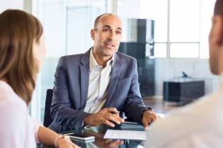 insurance agent working with clients in office | Guide to e&o insurance for insurance agents