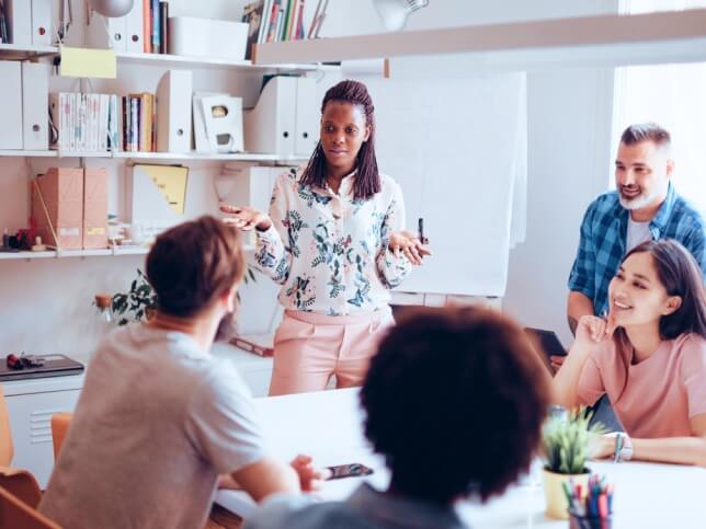 professional talking to a group of adults in a conference room