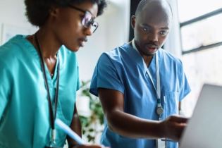 two nurses working on a computer | what is the best malpractice insurance for nurses