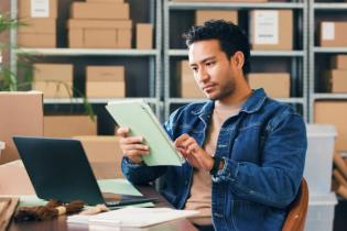 business owner working on tablet in warehouse comprehensive general liability insurance | What is comprehensive liability insurance?