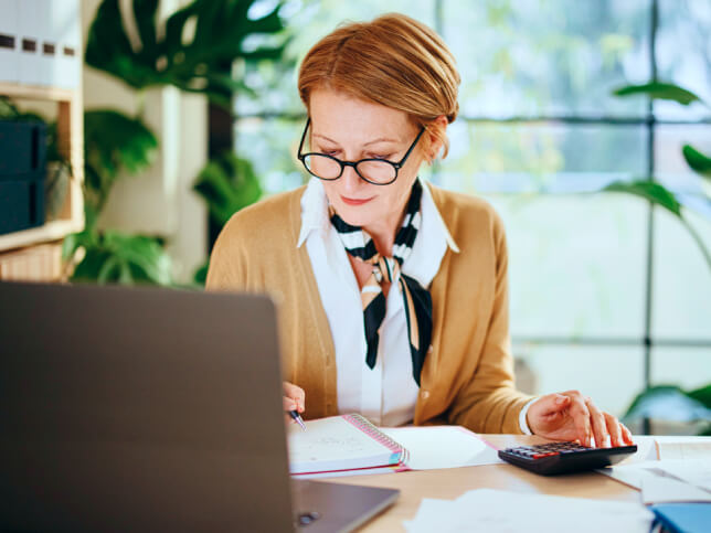 business professional sitting at her desk calculating insurance costs