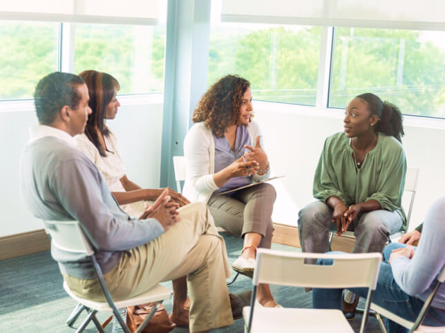 counselor working with a group of patients in chairs