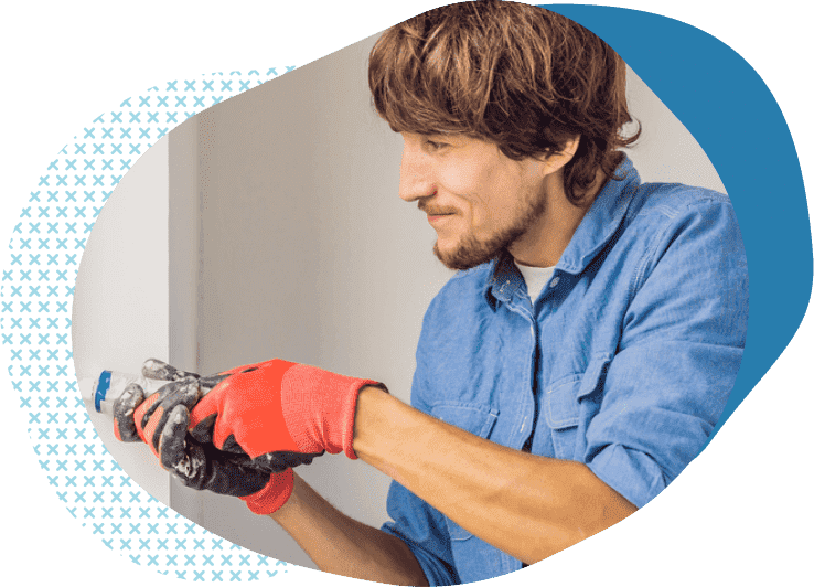handyman fixing a wall with power drill | handyman business insurance